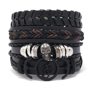 Set of four minimalist braided leather bracelets with skull and music note charms