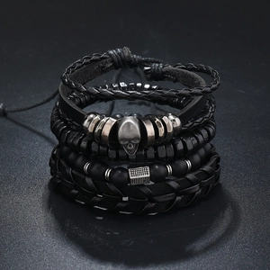 Detail of men's multilayer beaded bracelet set with black matte beads and skull charm