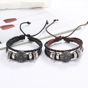 Vue détaillée de bracelets en cuir noir et marron avec un charme en relief vintage