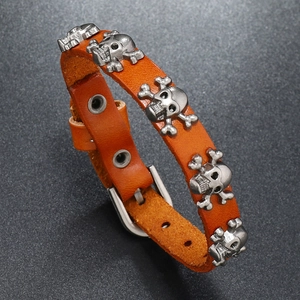 Detail view of brown leather punk bracelet with silver skull rivets and buckle closure