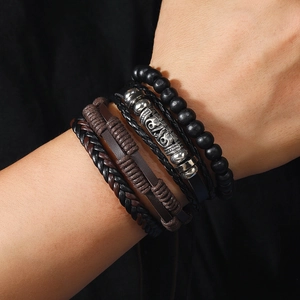 Detail of vintage men's multilayer bracelet set with wood beads and leather braids