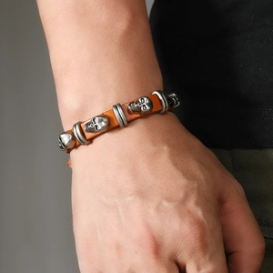 Close-up of punk style men's leather bracelet with silver skull metal charms and studs