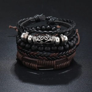 Close-up of four-piece layered men's bracelet set with leather, wood beads and metal charms