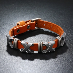 Gros plan sur un bracelet en cuir marron avec des détails de boucle en métal argenté