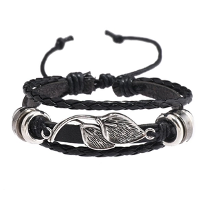 Détail du bracelet multicouche en cuir avec feuilles en métal et tresses noires