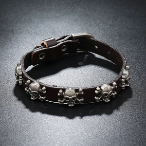 Detail view of skull rivets and adjustable buckle on punk style black leather bracelet