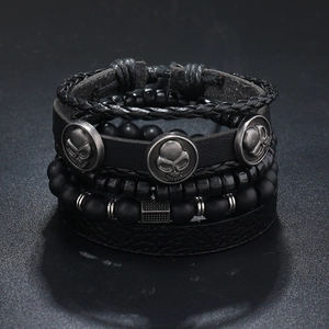 Detail of men's multi-layer leather bracelet set with beads and skull charms