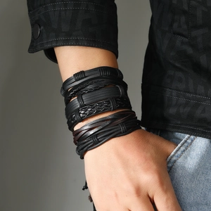 Close-up of black multi-layer woven leather bracelets on a male model's wrist
