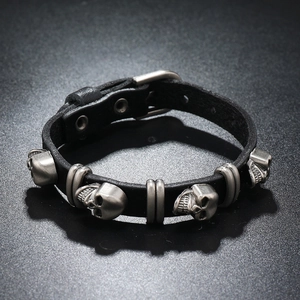 Detail of punk leather bracelet with five silver skull studs and adjustable buckle clasp