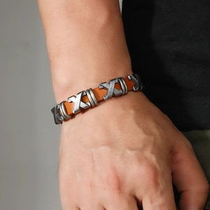 Gros plan d'un bracelet en cuir marron pour homme avec clous en métal argenté en X