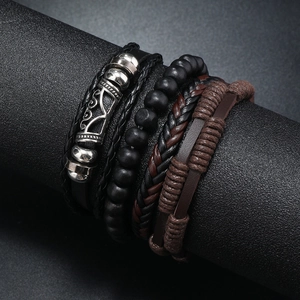 Close-up of men's multilayer leather bracelets with matte wood beads and crown charm