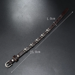 Detail showing skull charms on adjustable punk leather bracelet with belt buckle strap