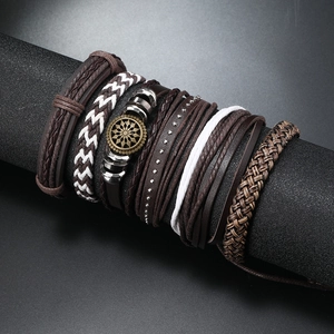 Handmade multilayer leather bracelet for men with vintage sunburst metal charm on display