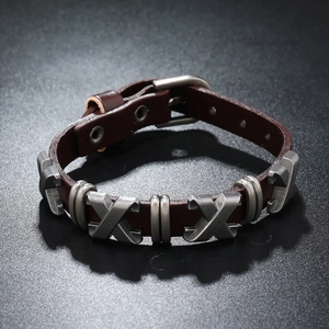 Détail d'un bracelet en cuir marron style punk avec boucle et ornements métalliques en X