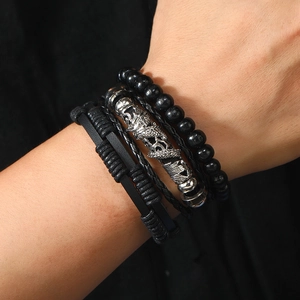 Close-up of men's multi-layer leather bracelets with black wooden beads and dragon charm