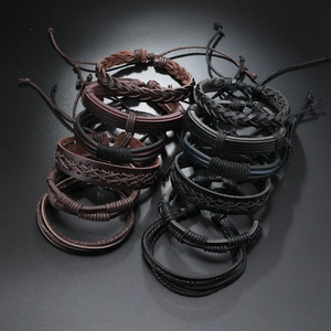 Dettaglio di bracciali in pelle intrecciata a mano con corde di cera regolabili e trame multistrato