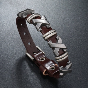 Vue macro d'un bracelet punk en cuir avec clous en X argentés et boucle réglable en métal
