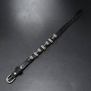 Detail of punk leather bracelet with silver alloy skulls and adjustable metal buckle