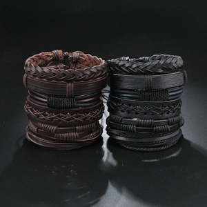 Dettaglio di bracciali multistrato in pelle intrecciata vintage neri e marroni scuri