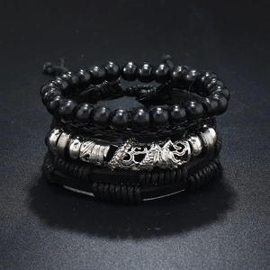 Close-up of a men's layered leather bracelet set featuring a silver dragon metal charm