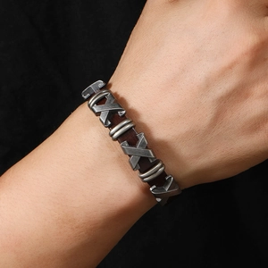 Détail d'un bracelet en cuir pour homme avec des accents métalliques en forme de X