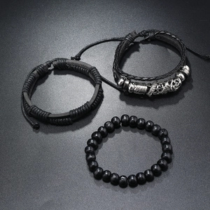 Detail of multi-layer men's leather bracelet set with wooden beads and silver metal charms