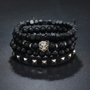 Close-up of men's multilayer bracelet set with matte black beads and lion head charm