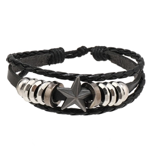 Détail d'un bracelet en cuir multicouche avec un pendentif étoile pentagramme en métal vintage