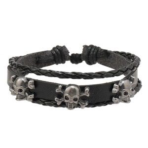 Détail macro du bracelet en cuir punk avec clous tête de mort et os en argent vintage