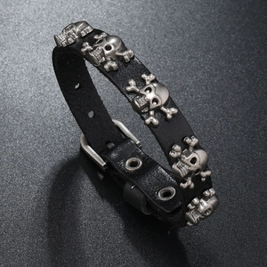 Detail of black punk leather bracelet showing silver skull rivets and buckle closure