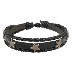 Détail de bracelets punk multicouches en cuir avec clous étoiles vintage et cordes tressées
