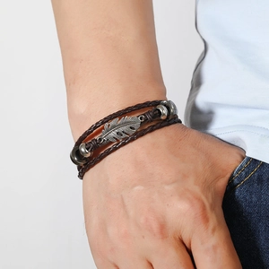 Vue détaillée du bracelet en cuir tressé multicouche avec pendentif plume argenté