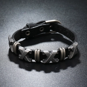 Détail macro du bracelet punk en cuir avec clous en X argentés et boucle réglable