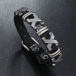 Détail d'un bracelet punk en cuir noir avec clous métalliques en X et boucle réglable
