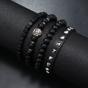 Detail of a 4-piece set of men's matte black beaded bracelets with a silver lion head charm