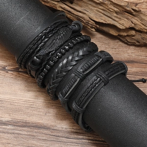 Black multilayer braided leather bracelet set for men on display with vintage wood background