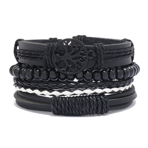 Detail view of multi-layer leather bracelet set with tree of life charm and black beads