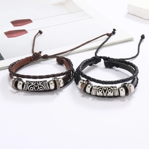 Détail de bracelets en cuir tressé multicouches avec perles en alliage et cordon réglable