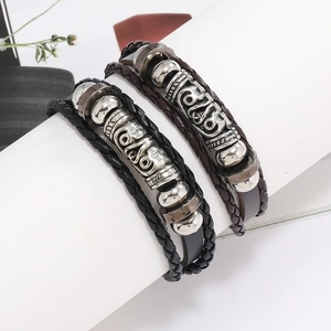 Gros plan de bracelets en cuir tressé noir et marron avec des perles en métal vintage
