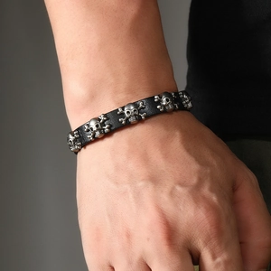 Macro shot of punk leather bracelet showing vintage silver skull studs and metal buckle detail