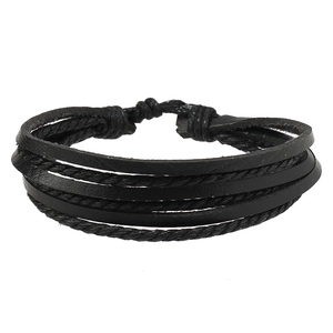 Dettaglio del bracciale multistrato in pelle nera intrecciata con chiusura regolabile