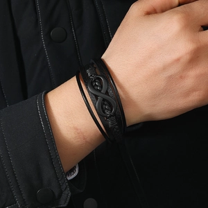 Detail of men's multi-layer braided leather bracelet with infinity symbol and magnetic clasp