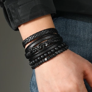 Close-up of men's multilayer black leather bracelet with treble clef and beads