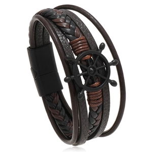Detail of multi-layer leather bracelet featuring a black helm charm and magnetic clasp