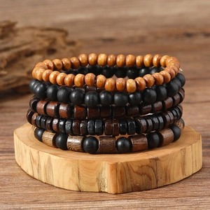 Detail eines fünfteiligen mehrlagigen Holzperlen-Armbandsets auf einem Natursockel