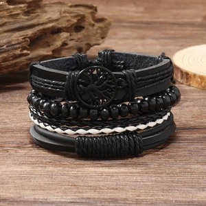 Detail view of multi-layer leather bracelets with Tree of Life charm on wood background