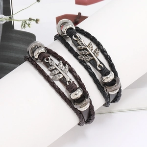 Détail de bracelets en cuir multicouches avec breloques feuilles argentées et perles