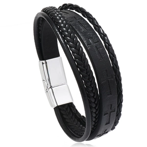 Macro detail of men's leather bracelet showing embossed cross and silver magnetic clasp