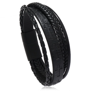 Detail of black leather braided bracelet with embossed cross pattern and matte magnetic clasp