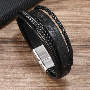 Close-up of men's leather bracelet featuring embossed cross pattern and silver clasp